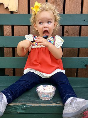 young girl enjoys a treat after being adopted by an eligible adoptive family