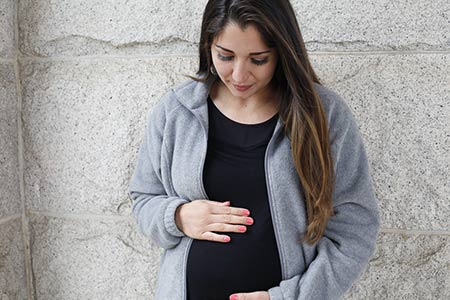 pregnant woman looks at her belly