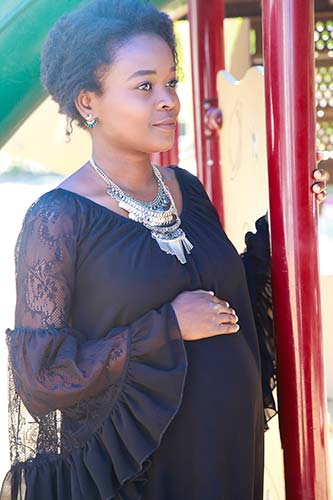 An African American woman posing near a red pole thinking about the benefits of adoption