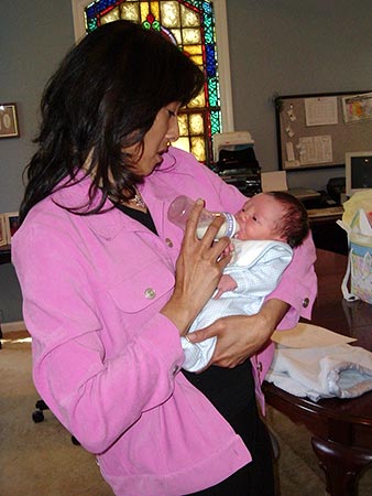 Veronica feeds adopted baby in her arms