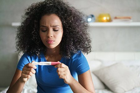 woman looking at pregnancy test