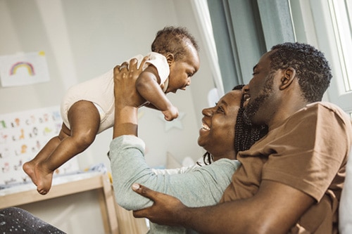 Happy African American adoptive couple with their baby